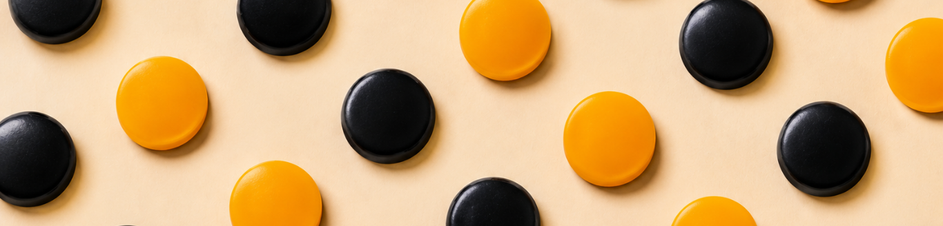 Black and orange pastilles on a cream surface - Makson Healthcare pastille manufacturing